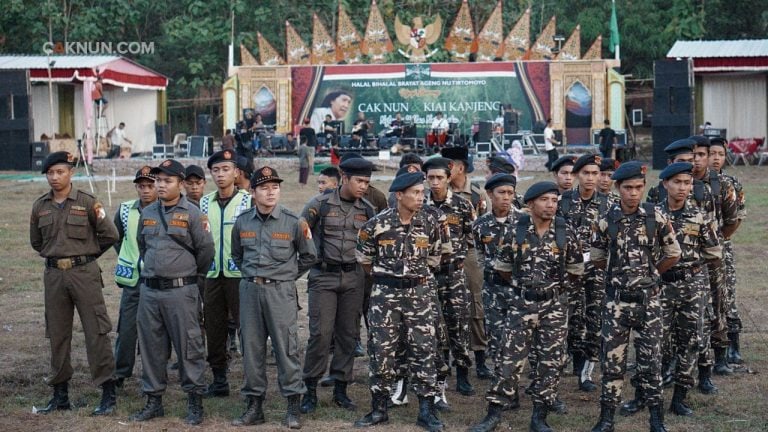 KiaiKanjeng melakukan cek suara di panggung, sementara Banser dan Pagar Nusa persiapan pengamanan.