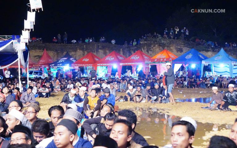 Meski jauh dari pemukiman dan tanah berlumpur karena hujan badai, jamaah Maiyah tetap datang dan duduk menyimak. Foto: Hariadi.